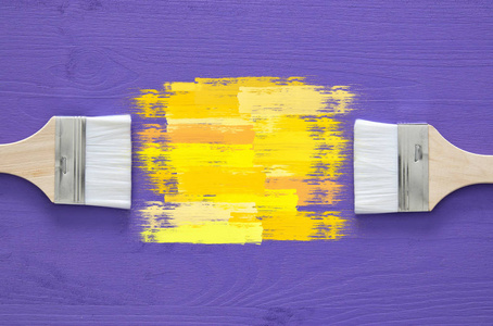 油漆刷和黄色中风紫色背景