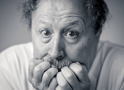 害怕的老人的肖像在人的情感和面部表情隔绝在中性背景中的恐惧表达