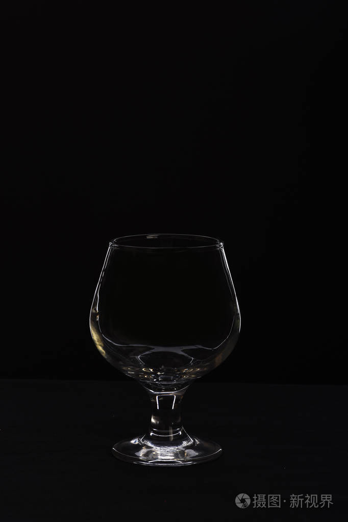 科涅克白兰地或威士忌孤立在黑色背景上的空杯子