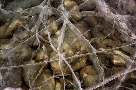 贝加尔湖深透明的冰裂开了。在贝加尔湖的鹅卵石底部