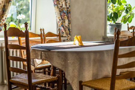 空的餐馆桌在旅馆与黄色餐巾在它窗口座椅与明亮的光