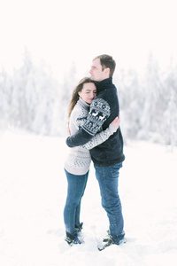 幸福恩爱的夫妻在下雪的冬天森林散步一起度过圣诞假期。户外季节性的活动。生活方式捕获
