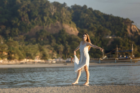 菲律宾巴拉望岛日落海面上穿白色连衣裙的妇女