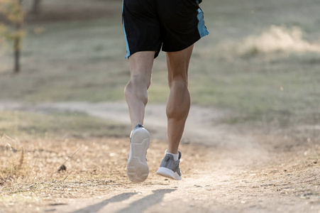在秋天的日落时, 在乡村慢跑训练中, 在健身和健康的生活方式概念中, 运动和肌肉发达的腿被撕破的运动员的背部欣赏