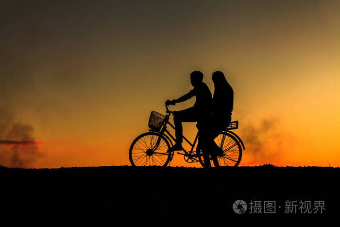 甜蜜的情侣在爱快乐的时光和自行车在bea的剪影