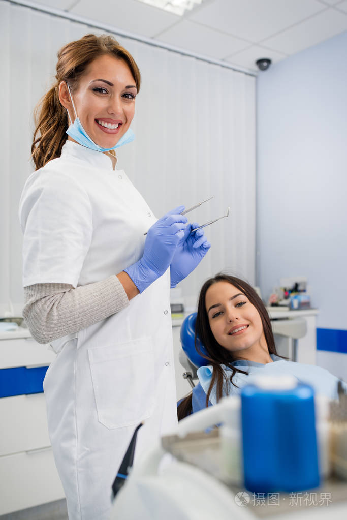 愉快的年轻女性患者与她的牙医
