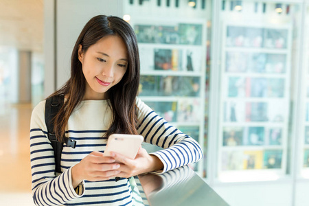 女背包客检查手机上的电子邮件