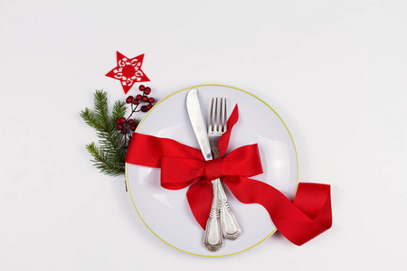 圣诞组合板, 餐具, 松树分枝, 丝带和红色浆果在白色的桌子上。寒假和节日背景。圣诞前夜晚餐, 新年食品午餐。顶视图