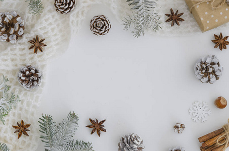 圣诞节新年框架。圣诞手工制作的礼品盒, 松果, 冷杉树枝, 肉桂棒, 八角星在白色背景。顶部视图, 平面布局, 复制空间。英雄标