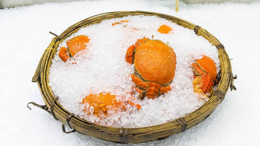 鲜橙色螃蟹在冰篮子里