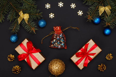 圣诞装饰。礼品盒, 冷杉树枝与锥和玩具球在黑色背景。顶部视图。圣诞贺卡概念