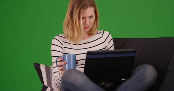 可爱的金发碧眼的女人在绿色屏幕上浏览笔记本电脑互联网的肖像