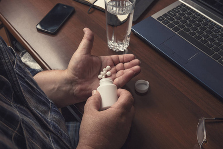 老年人服用药片或药物片剂或药物在手从瓶子在家