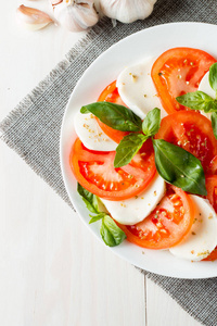 特写照片的 caprese 沙拉与成熟的西红柿, 罗勒, 水牛芝士干酪。意大利和地中海的食物概念。新鲜健康的有机膳食。起动机和开
