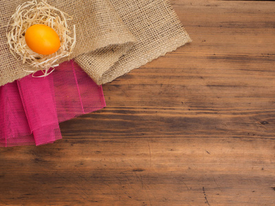 农村生态背景与橙色鸡鸡蛋和稻草的粗麻布和旧木板背景上。从顶视图。复活节贺卡的创作背景