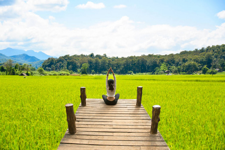 健康的女人，在自然界中，背景稻田桥上练瑜伽