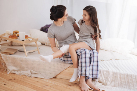 好笑的母亲和女儿享受在家的谈话照片