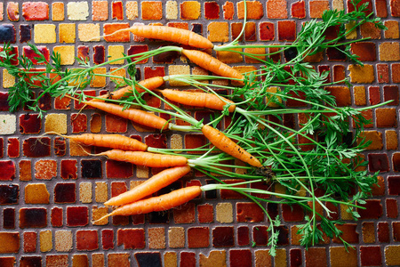 瓷砖桌上的迷你胡萝卜蔬菜。