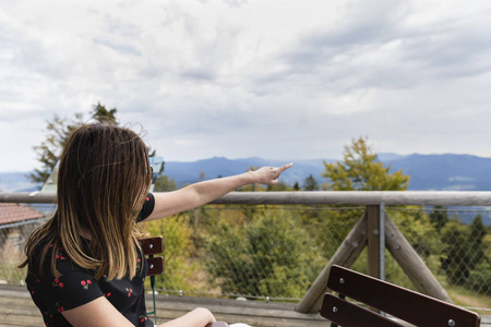 女人看着惊人的树林和山区在夏天, 旅游概念, 文字空间