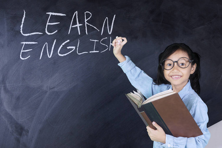 女孩与学习英语单词在黑板上照片