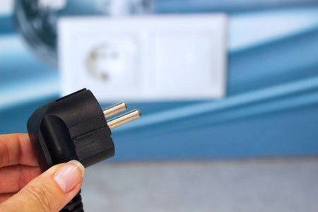 拔出或插入概念,手中拿着电插头照片