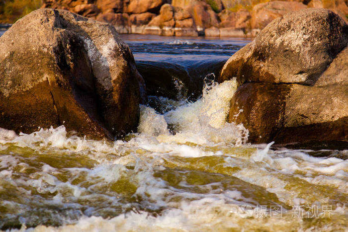 强大的水流围绕着石头急流飞溅和泡沫关闭