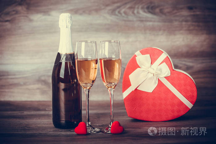 情人节。香槟, 酒杯和礼物, 配有红色的心装饰。预约, 生日。理念 幸福, 节日