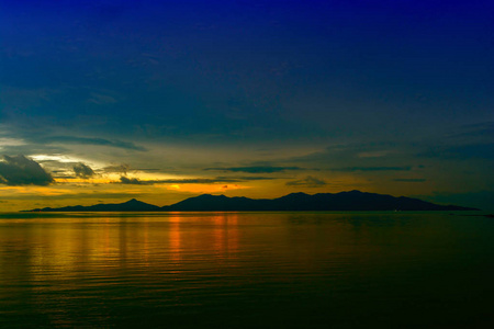 黎明天空清晨暮色在日出前的水面上反射在海洋中的岛屿上