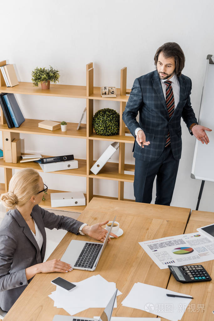 年轻的商人站在船边, 在办公室开会时与年轻的女商人交谈