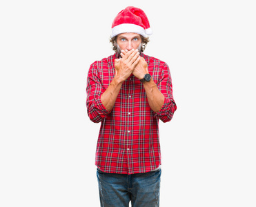 英俊的拉美裔男子模型穿着圣诞老人圣诞节在孤立的背景震惊地覆盖口与手错误。秘密概念