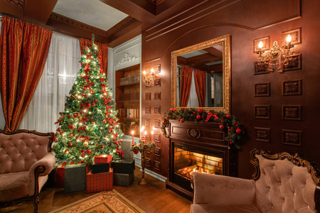 圣诞晚会圣诞树上的礼物。带壁炉的典雅公寓。带书架的房间