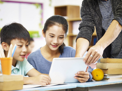 亚洲小学生使用数码平板电脑上课照片
