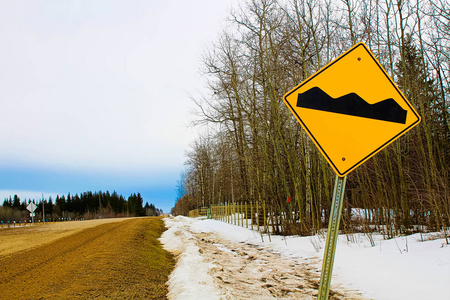 警告崎岖不平的道路前方标志照片