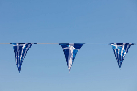 小三角塑造了希腊国家的小旗子反对蓝天。装饰中的国家标志
