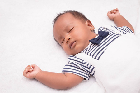 新生的亚洲男孩婴儿睡在白色的毛绒布