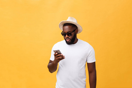 愉快的非洲裔美国人穿着白衬衫使用手机应用程序。快乐的黑皮肤嬉皮士家伙阅读新闻从社交网络在手机