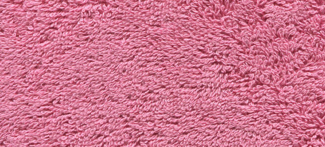 柔和的粉红色的毛巾纹理。粉红色毛巾的质地。棉毛巾背景和文本