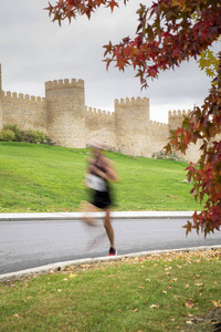 在阿维拉半程马拉松比赛中, 在墙边跑的男人