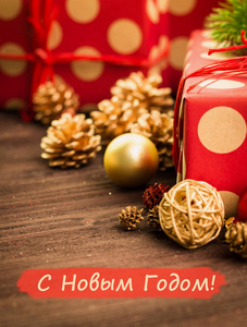 圣诞节和元旦节日节日装饰, 金球, 冷杉锥, 树枝和木星与礼物包裹在红色纸与金黄木头背景与文字新年快乐 在俄罗斯新年快乐 在