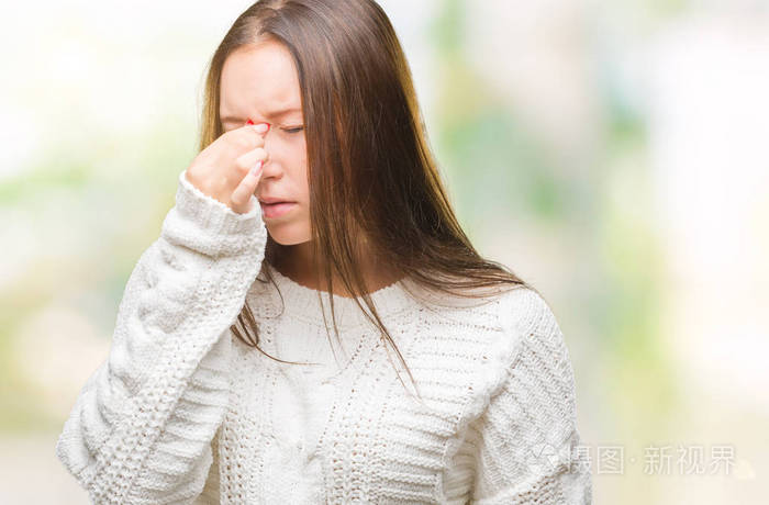年轻美丽的白人妇女穿着冬季毛衣在孤立的背景疲惫揉