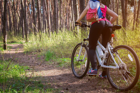 年轻女子骑着自行车在森林里