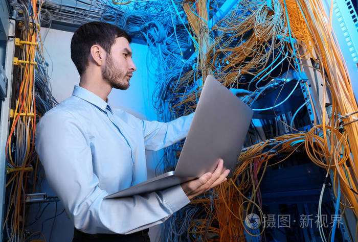 年轻的工程师,与在服务器机房的笔记本电脑
