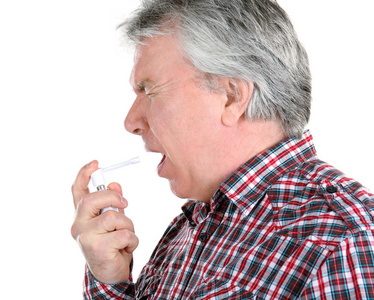 生病的老人在白色背景上使用喉头喷雾器