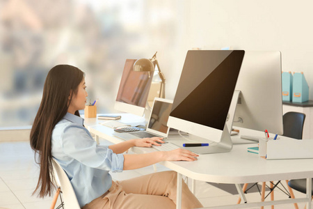 数据库程序窗口在办公室工作的年轻女性程序员照片