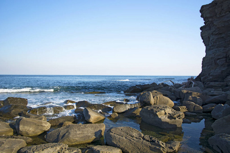 海拔高高的悬崖，悬崖潜入大海，许多飞溅的海浪和石头