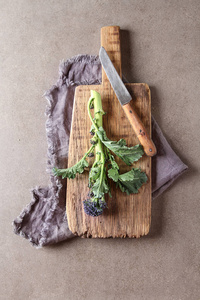新鲜的紫色花椰菜在木板上。素食主义者的食物。黑暗的背景和目标