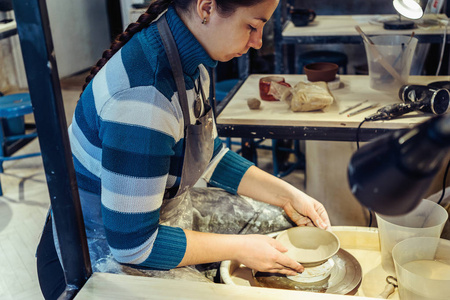 年轻女子制陶工人工作与粘土