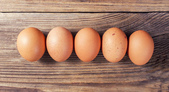 有机鸡蛋排列成一排在一张小木桌