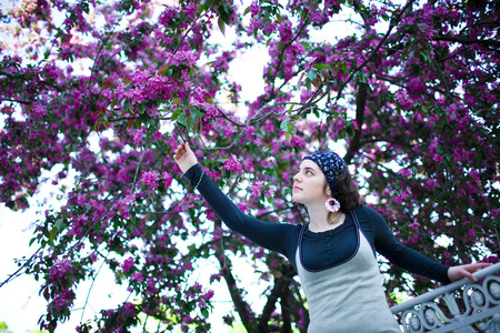 一个年轻漂亮的女孩在一棵开花的树的画像。美丽的春天不过敏