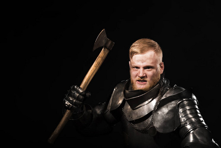 用斧子在黑色背景上的盔甲的骑士照片